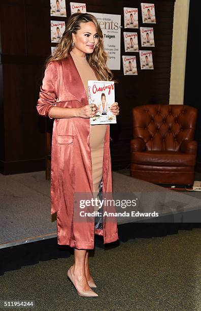 Model Chrissy Teigen poses before signing copies of her book "Cravings: Recipes For All The Food You Want To Eat" at Barnes & Noble at The Grove on...