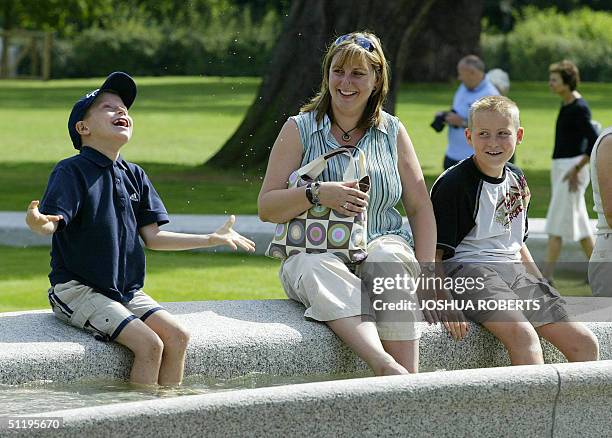 Boy flicks water into the air as he dips his feet in the Princess Diana Memorial Fountain in London's Hyde Park 20 August 2004. The accident-plagued...