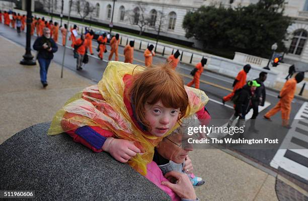 Mary Evelyn O'Neill rides on the shoulders of her resting father, Patrick O'Neil, as activists from Witness Against Torture, Amnesty International...