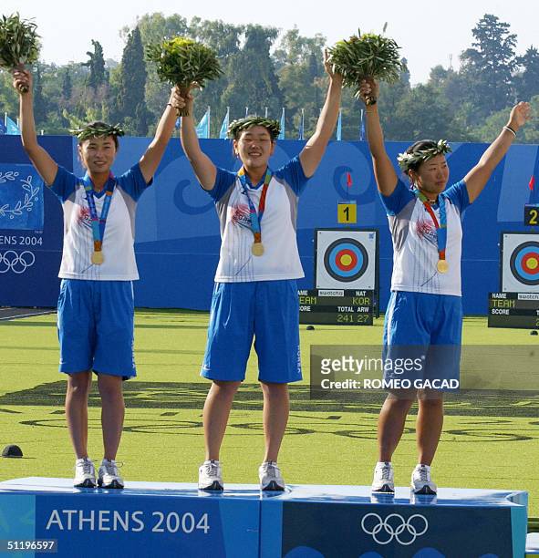 Olympic champions of the South Korean women's archery team wave to the crowd at Panathinaiko Stadium during the awards ceremony for the 2004 Athens...