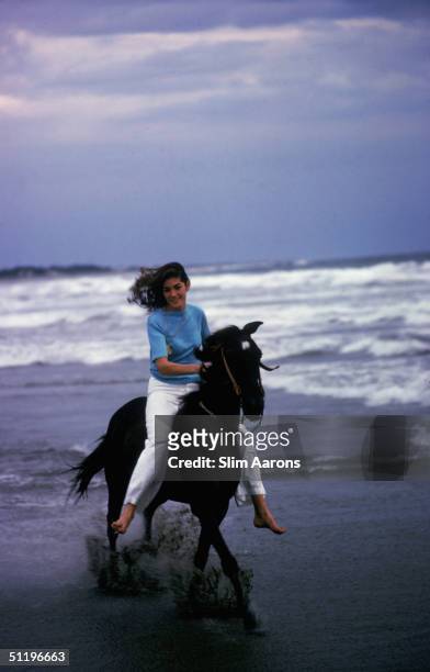 American society girl Minnie Cushing rides her horse along a beach in Acapulco, 1972.