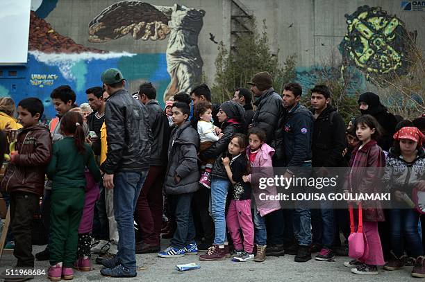 Migrants and refugees queue for a food distribution by an NGO in the port of Piraeus, after their arrival from the islands of Lesbos and Chios on...