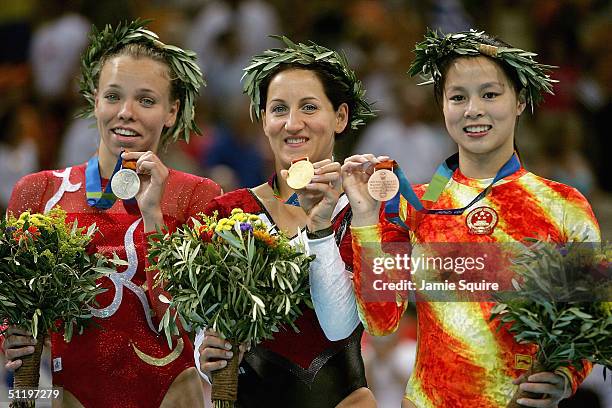 Silver-medalist Karen Cockburn of Canada, gold medalist Anna Dogonadze of Germany, and bronze medalist Shanshan Huang of China pose with their medals...