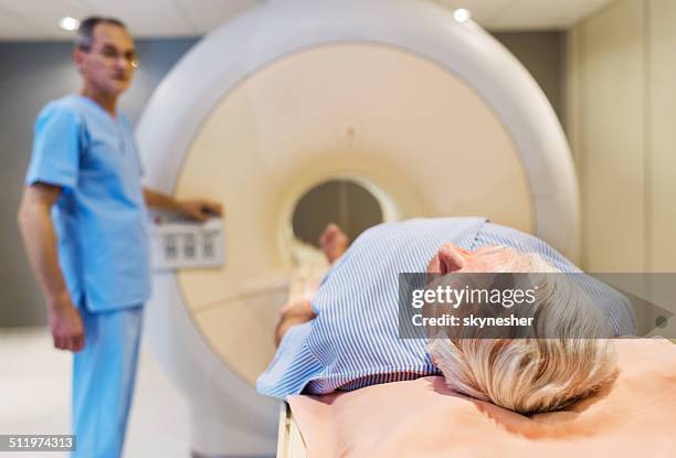 senior receiving an mri scan. - pet scan machine stock pictures, royalty-free photos & images