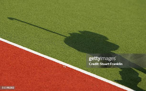 The shadow of a hockey player is cast across the field during the match between Germany and South Africa in the women's field hockey preliminaries on...