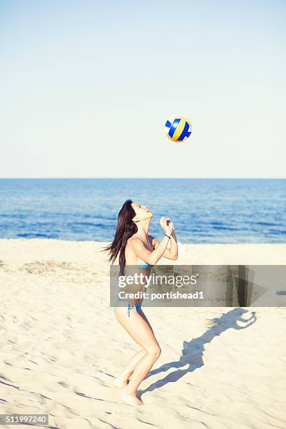 young woman playing volleyball on the beach - girls beach volleyball stock pictures, royalty-free photos & images