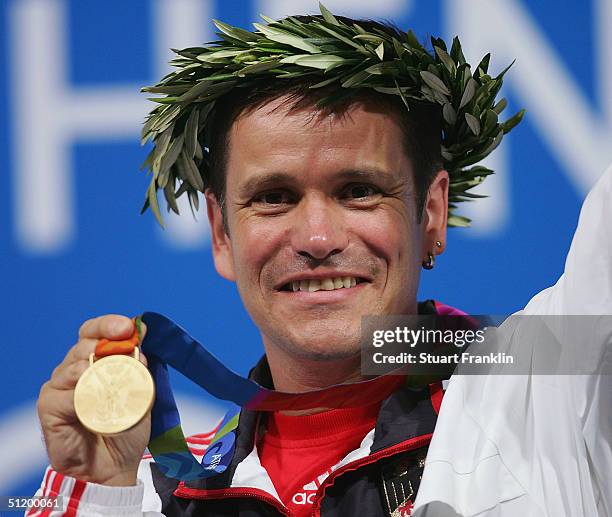 Gold medalist Ralf Schumann of Germany receives the medal for the men's 25 metre rapid fire pistol event on August 21, 2004 during the Athens 2004...