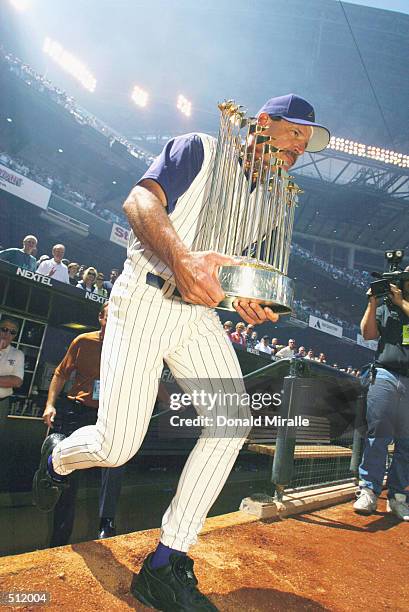 Manager Bob Brenly of Arizona Diamondbacks walks out to the field with the World Championship Trophy before the game against the San Diego Padres...