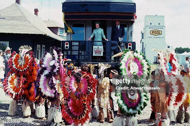 Queen Elizabeth ll and Prince Philip, Duke of Edinburgh are greeted by Native Americans as they arrive by train during a tour of Canada on August 01,...