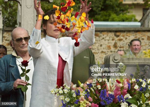 La femme du comédien et humoriste Jean Yanne, Christianne Fugger lance des fleurs au dessus de la tombe de son époux, le 30 mai 2003 au cimetière des...