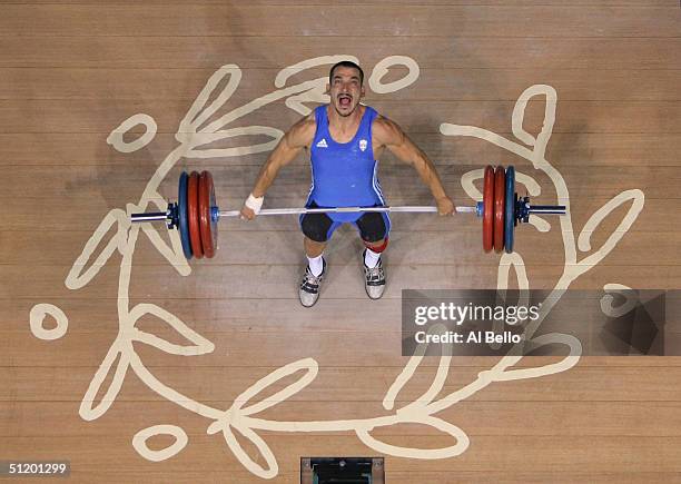 Pyrros Dimas of Greece shouts as he attempts to make a lift in the men's 85 kg category weightlifting competition on August 21, 2004 during the...