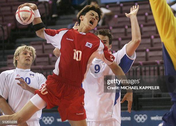 Korea's Chan-Yong Park attempts to score while Slovenia?s Luka Zvizej and Jure Natek try to block him during Olympic Games handball preliminary Group...