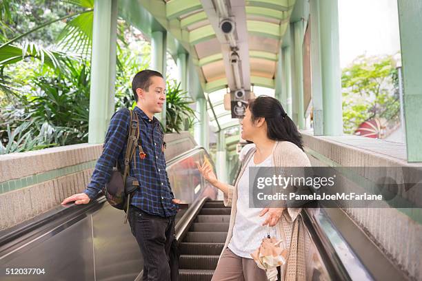 asiatischen mann und frau reiten mid-levels rolltreppe, hong kong - sheung wan stock-fotos und bilder