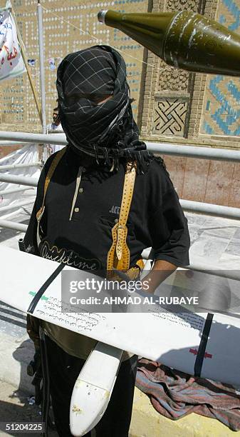 Militiaman loyal to Iraqi Shiite cleric Moqtada Sadr at the shrine of Imam Ali in Najaf displays 22 August 2004 a US military drone which the militia...