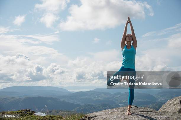 woman practicing yoga on top of a mountain - tree position stock pictures, royalty-free photos & images