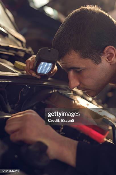 close up of a mechanic examining an engine. - car engine close up stock pictures, royalty-free photos & images