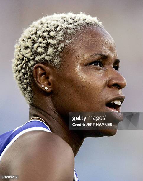 Linda Ferga-Khodadin of France competes in heat two, round one of the women's 100m hurdles, 22 August 2004, during the Olympic Games athletics...