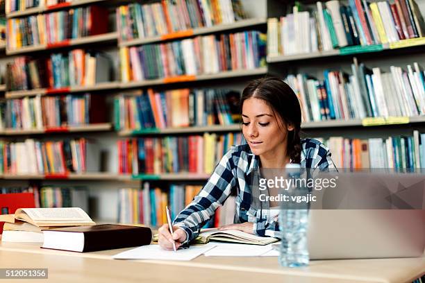 student using laptop for taking notes to study - library　woman stockfoto's en -beelden