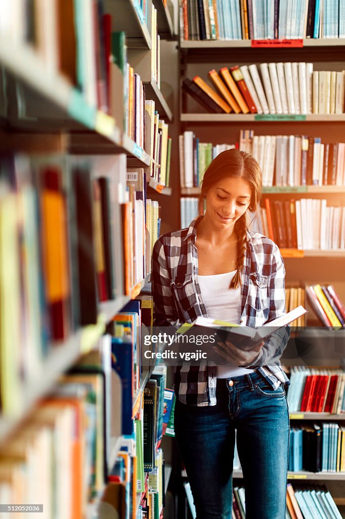 Frau in der Bibliothek lesen Buch.