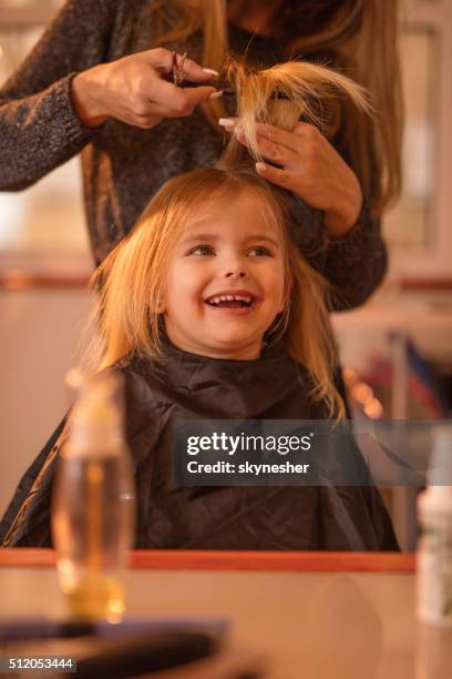 cute little girl during hair cut at hair salon. - hairstyle stock pictures, royalty-free photos & images