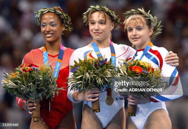 Silver medallist Annia Hatch, Romanian gold medallist Monica Rosu and Russian bronze medallist Anna Pavlova pose on the podium after the women's...