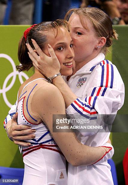 French Emilie Lepennec is congratulated by teammate Marine Debauve after winning the gold medal in the women's uneven bars final 22 August 2004 at...