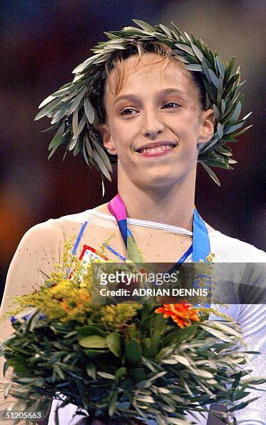 French Emilie Lepennec celebrates on the podium after winning the gold medal in the women's uneven bars final 22 August 2004 at the Olympic Indoor...