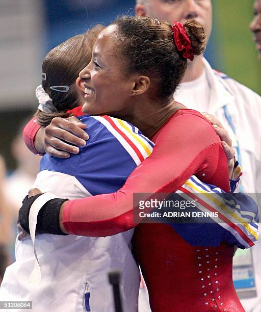 Silver medallist Annia Hatch is congratulated by Romanian gold medallist Monica Rosu after the women's vault final 22 August 2004 at the Olympic...