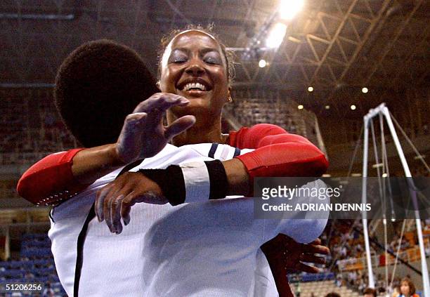 Silver medallist Annia Hatch is congratulated by an unindentified staff member after winning the silver medal in the women's vault final 22 August...