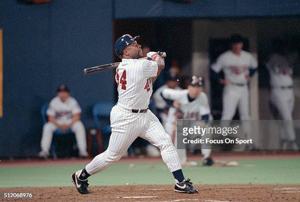 Outfielder Kirby Puckett of the Minnesota Twins swings and watches the flight of his ball against the Atlanta Braves in Game 6 of the World Series...