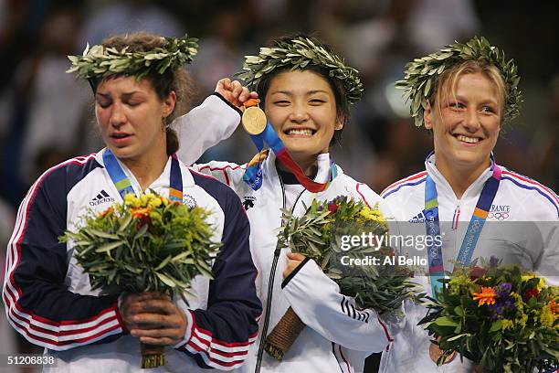 An emotional Sara McMann of the USA silver medalist, Kaori Icho of Japan Gold medalist and Lise Legrand of France bronze medalist stand on the podium...