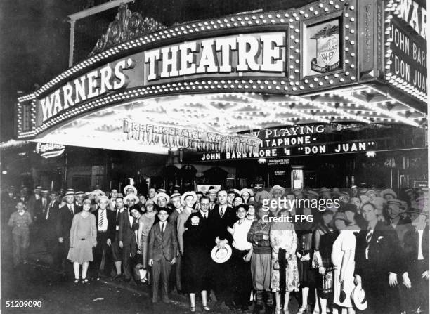 Crowd poses under the kiosk of Warners' Theatre at 1579 Broadway, New York, New York, August 1926. The kisok advertises both Alan Crosland's 1926...