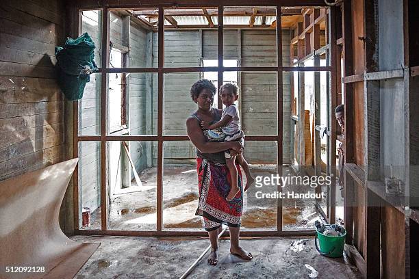 In this handout image supplied by the UNICEF, Kolora holds her daughter Semaima in what is left of her home in the aftermath of Tropical Cyclone...