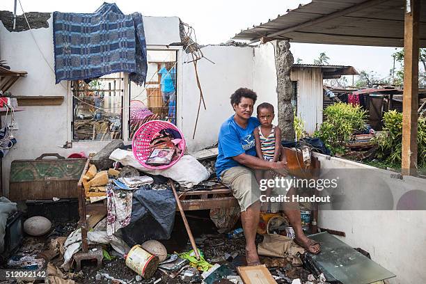 In this handout image supplied by the UNICEF, Kalisi holds her son Tuvosa in the remnants of her house in Rakiraki District in Ra province on...