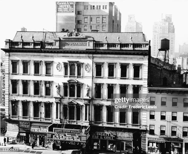 Exterior view of the Grand Opera House, 8th Ave & 23rd Street, New York, New York, late 1936. The kiosk advertises a double bill of Mitchell Leisen's...