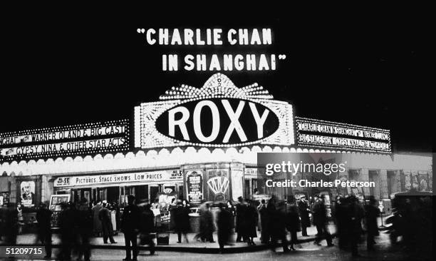 Moviegoers gather at the entrance ot the Roxy Theatre at 153 W. 50th Street, New York, New York, late 1935. The kiosk advertises 'Charlie Chan In...