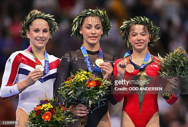 Silver medallist Carly Patterson, Romania's gold medallist Catalina Ponor and Romania's bronze medallist Alexandra Georgiana Eremia are seen on the...