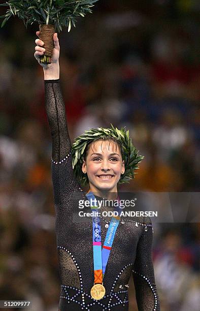 Romania's gold medallist Catalina Ponor smiles on the podium of the women's beam, 23 August 2004 at the Olympic Indoor Hall in Athens during the...
