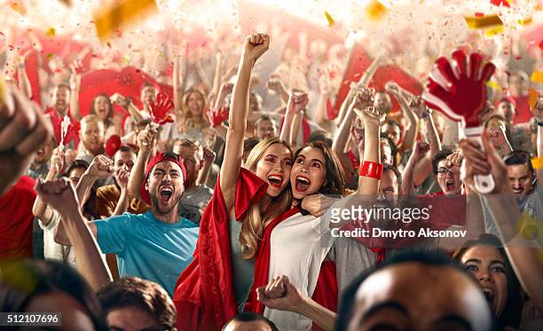 sport fans: two girls embrace each other - fan enthusiast stock pictures, royalty-free photos & images