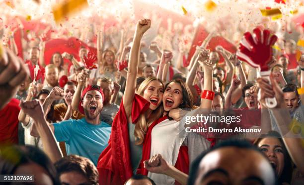 sport fans: two girls embrace each other - fan enthusiast stock pictures, royalty-free photos & images