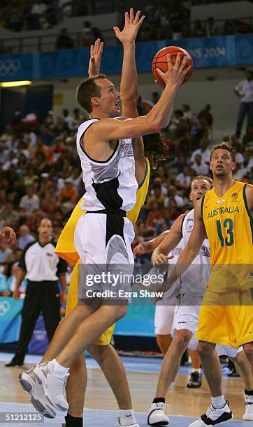Phillip Jones of New Zealand goes to the basket against Jason Smith of Australia in the men's basketball classifications game on August 24, 2004...