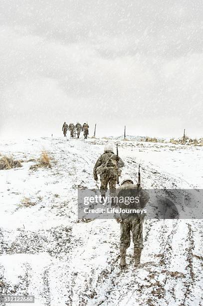 battle weary wwii us squadron walking up a muddy hill - world war ii america stock pictures, royalty-free photos & images