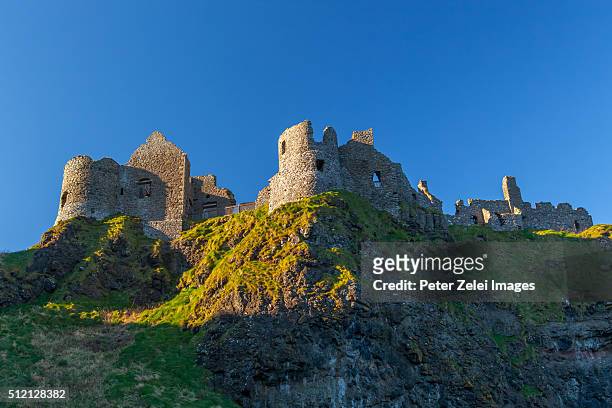 dunluce castle, a now-ruined medieval castle in northern ireland - dunluce castle stockfoto's en -beelden