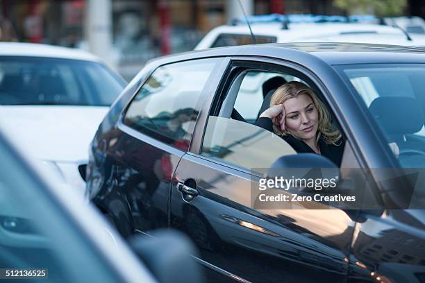 bored businesswoman driving in city traffic jam - car traffic stockfoto's en -beelden