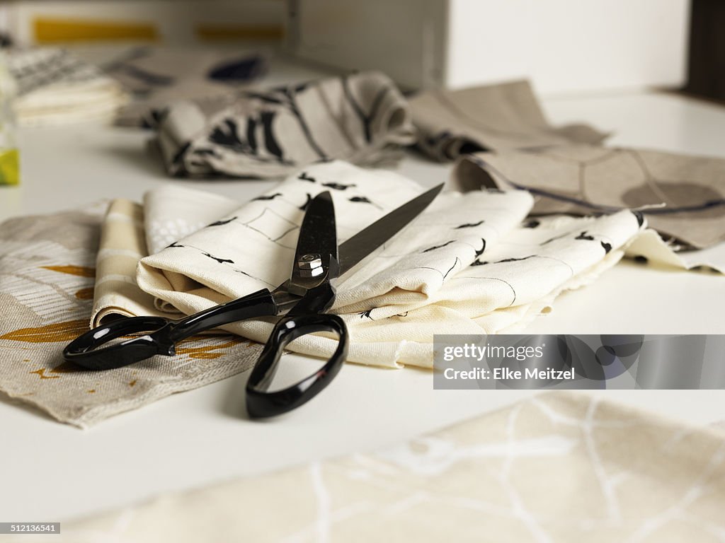 Pair of scissors and fabric on work table