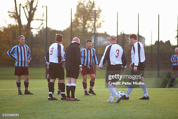 referee and football players settling dispute - referee stock pictures, royalty-free photos & images