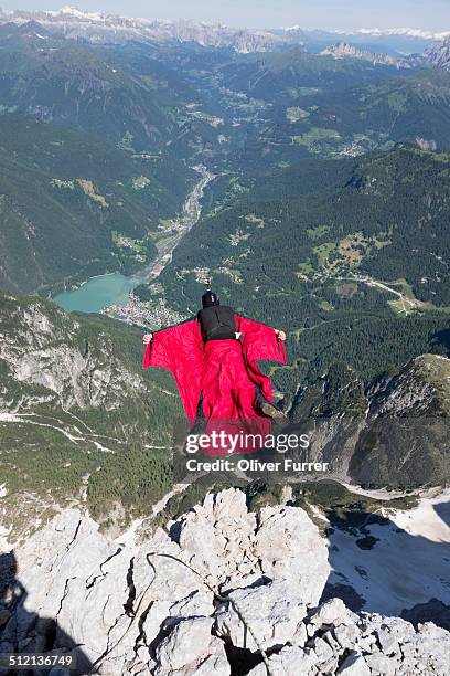 mature man base jumping from mountain, alleghe, dolomites, italy - salto desde acantilado fotografías e imágenes de stock