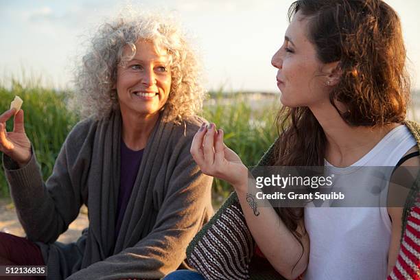 two women having picnic on bournemouth beach, dorset, uk - mature women eating stock pictures, royalty-free photos & images
