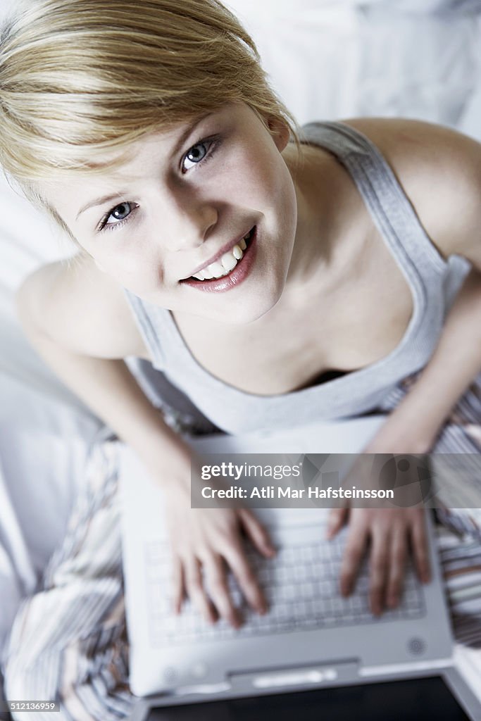 Teenage girl using laptop, high angle