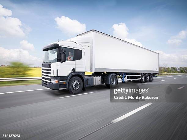 freight truck on the move on motorway - flatbed truck stock-fotos und bilder